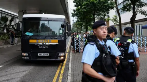 A prison van arrives ahead of the national security verdict for three former leaders of a disbanded group that organised annual Tiananmen Square vigils, charged with inciting subversion of state power, outside West Kowloon Magistrates' Courts