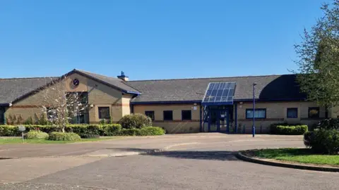 NeneGate School, a single-story pale brick building.