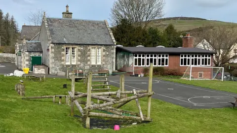 A small school in the Borders with a playground and play equipment outside
