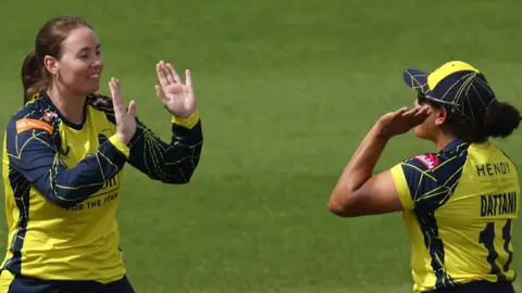 Amanda-Jade Wellington of Hampshire Hawks Women celebrates claiming a wicket with team-mates 