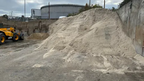 Brighton & Hove City Council A huge pile of grit with a yellow JCB gritter in site