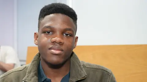 Qays Najm/BBC Nathaniel, a 17-year-old student at Luton Sixth Form College. He is looking directly at the camera and is wearing a blue shirt with a khaki jacket.