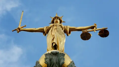 Lady Justice, holding scales and a sword, on top of the Central Criminal Court, also referred to as Old Bailey, in central London