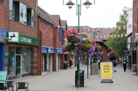 A generic image taken in the town centre showing Lloyds Bank and other premises on the left and in the middle and a pedestrianised area in the bottom part of the photo.