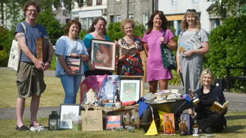 Wigtown Book Festival A group of writers holding books, art and bottles