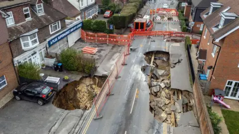 Getty Images An aerial image of a village main road, with a large hole opened up in the middle of the tarmac