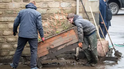 PA The clean-up operation in Mytholmroyd in February 2020 after the town was hit by flooding linked to Storm Ciara 