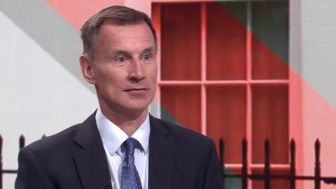 BBC Jeremy Hunt wearing a suit while appearing on Sunday with Laura Kuenssberg.