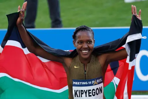 GEOFFROY VAN DER HASSELT/AFP Kenya's Faith Kipyegon reacts after winning and beating the world record in the women's 1500m during the "Meeting de Paris" Diamond League athletics meeting at the Charlety Stadium in Paris on July 7, 2024. Kipyegon clocked 3min 49.04sec, improving by 0.07sec her previous best set in Florence in June 2023. (Photo by Geoffroy VAN DER HASSELT / AFP