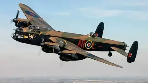 BBMF A Lancaster bomber in the air with camouflage colouring.