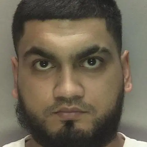 West Midlands Police Azeem Hussain in a photo taken by police with a black beard, short black hair and a white top