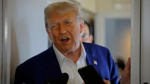 Donald Trump speaks to reporters onboard Air Force One en route to the NATO summit in The Hague, Netherlands, June 24, 2025. 