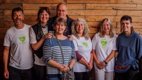 Dom Thompson A group of people from the Heavens Valley Community Benefit Society smiling