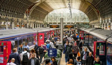 Getty Images Crowd of people on the platform after arriving at London Paddington railway station.