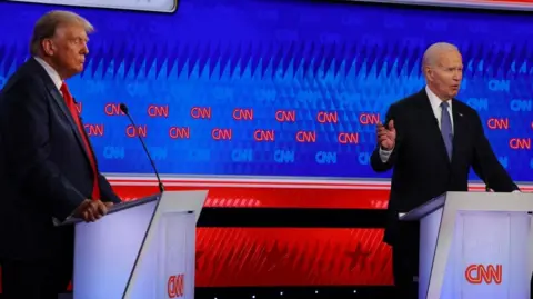 Donald Trump and Joe Biden stand at podiums during the debate