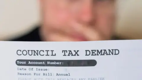 Getty Images A man looking at his council tax demand