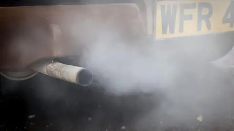 Getty Images Fumes are seen leaving the exhaust pipe of an old Ford Cortina car.