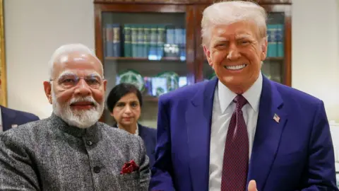 Getty Images Indian Prime Minister Narendra Modi, seen wearing a grey suit, with US President Donald Trump in a blue suit and a checked red tie, meeting at the White House in Washington DC on 13 February 2025. 