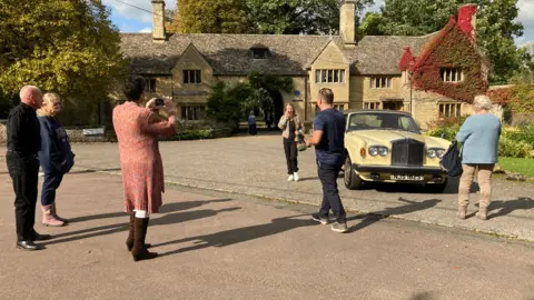 Fans take pictures of Robin Gibb's house and car.