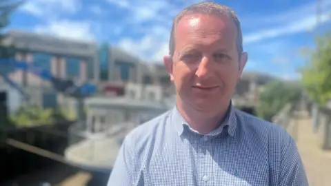 A man standing in the sunshine