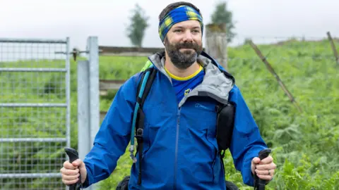 Perthshire Picture Agency/PA Paul Choat climbing Schiehallion in Perthshire, as part of his challenge of climbing all of Scotland’s 282 tallest mountains. He is wearing a blue jacket and blue and yellow headband.