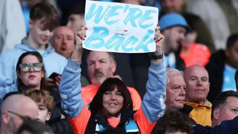 Coventry City fan holding up a sign reading We're Back
