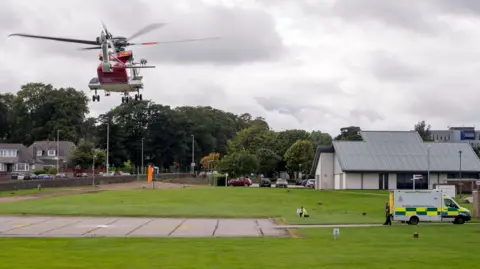 Getty Images A coastguard helicopter landing at Aberdeen Royal Infirmary. An ambulance is parked near the landing site