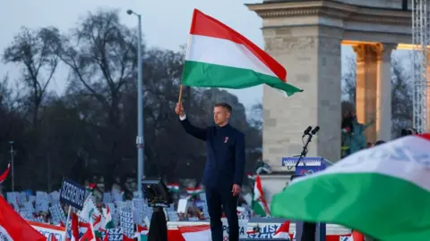 Reuters A man holds a red, white and green Hungarian flag