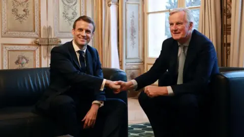  Ludovic Marin/Pool/AFP Macron shakes hands with Barnier