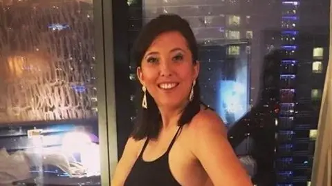 Handout Francesca Vincent is pictured smiling at the camera. She has long dark hair, and is wearing a black dress with dangling earrings. She is stood in front of a window at night. 