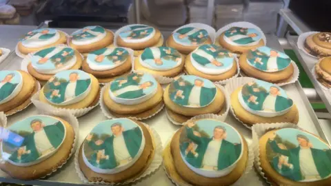 Three rows of German biscuits with an image of Rory McIlroy in his Green Jacket stuck to the top of each biscuit.