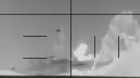 A black and white image of a ship being hit by a torpedo