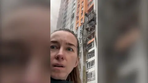 BBC Ukrainian Journalist Anastasiya Gribanova standing outside her apartment block which was hit during overnight Russian strikes