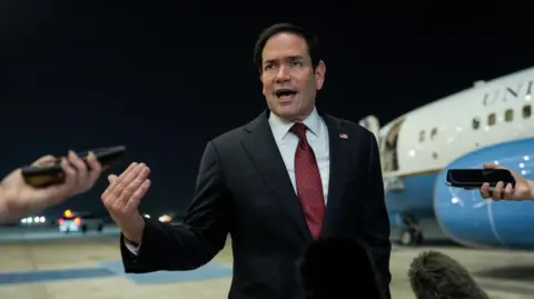 Secretary of State Marco Rubio speaking to reporters after landing in Abu Dhabi