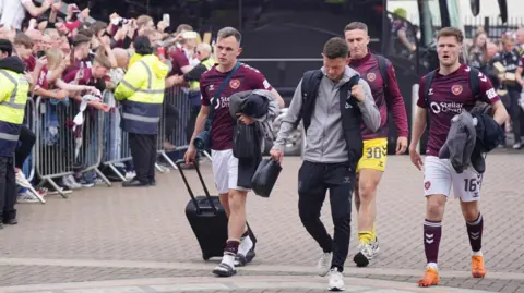 PA Media Defeated Hearts players were met by crowds of fans as they returned to Tynecastle