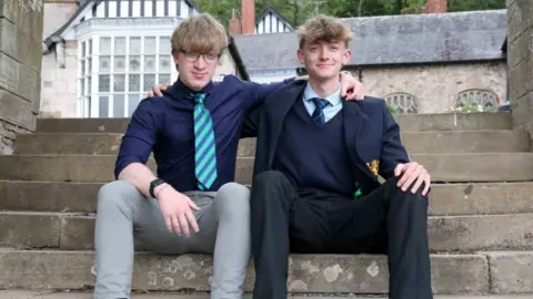 Rick Matthews A man with brown hair and glasses, wearing a blue shirt with a stripey tie, next to boy with also brown hair