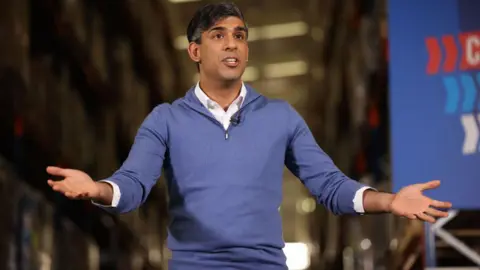 Rishi Sunak holds his hands open while campaigning in the general election
