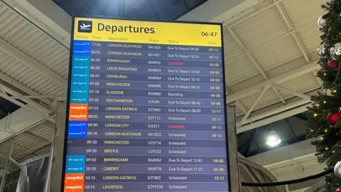 Close-up of a flight departure board in an airport terminal. 