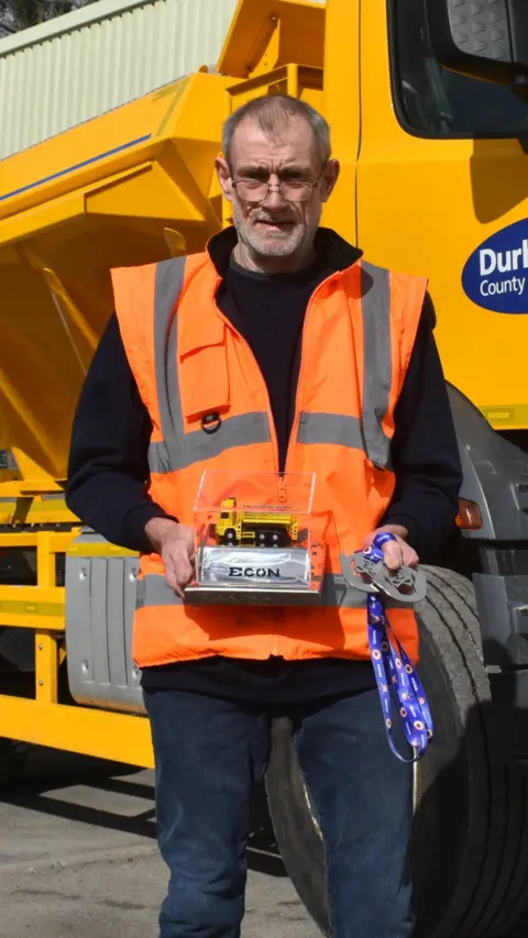 Gary Lawson pictured holding his awards for being named Gritter Driver of the Year.