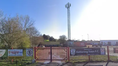 Red gates and railings at a football ground