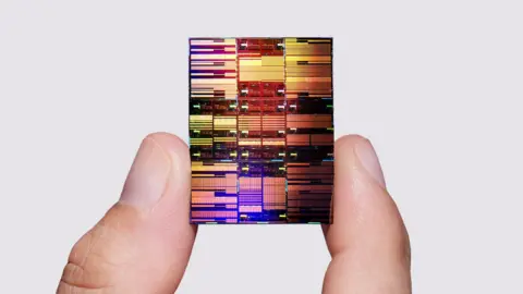 Researcher holding IBM's sub-1 nm node chip