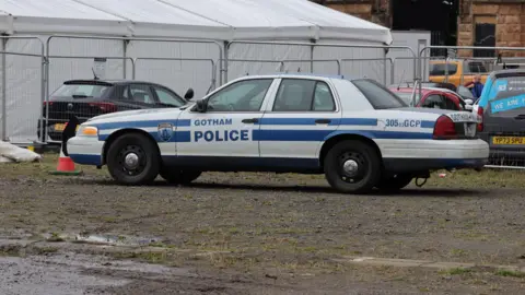 PA Media A police car for a film, with Gotham Police written on the side of the car.
