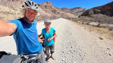 Tandem Travel Dave and Helen take a selfie on their bike in a desert