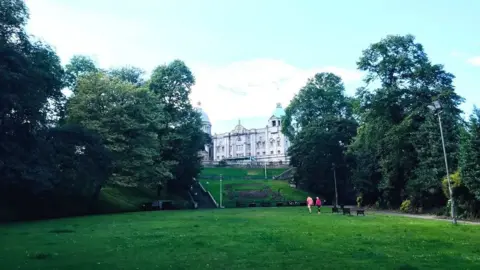 A previous image of Union Terrace Gardens in Aberdeen, people walking across the grass in the middle.