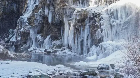 NurPhoto via Getty Images A frozen waterfall is visible during a cold winter day in Drung, west of Srinagar, in Indian-administered Kashmir. 