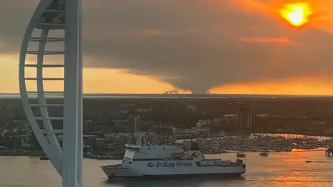 Robert Stiby New Forest fire seen from Portsmouth with the Spinnaker Tower and ferry in the foreground.