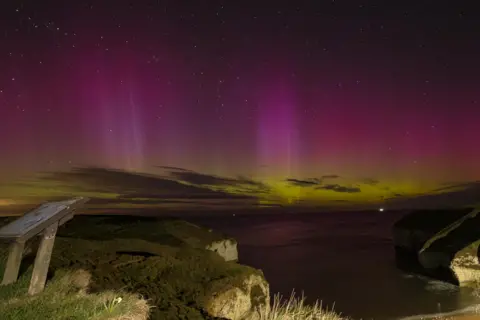 Stuart The cliffs at Flamborough are lit up at night by the purple and green aurora of the Northern Lights.