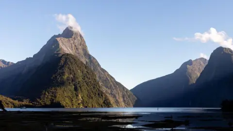 Getty Images Mitre Peak, a steep mountain on the country's South Island. The top of the peak is very pointed, and drops directly into water.