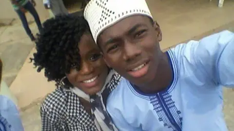 Elizabeth Alabi Elizabeth and Emmanuel as teenagers taking a selfie together.