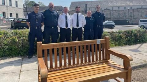 Members of Royal Navy standing by new reflection bench